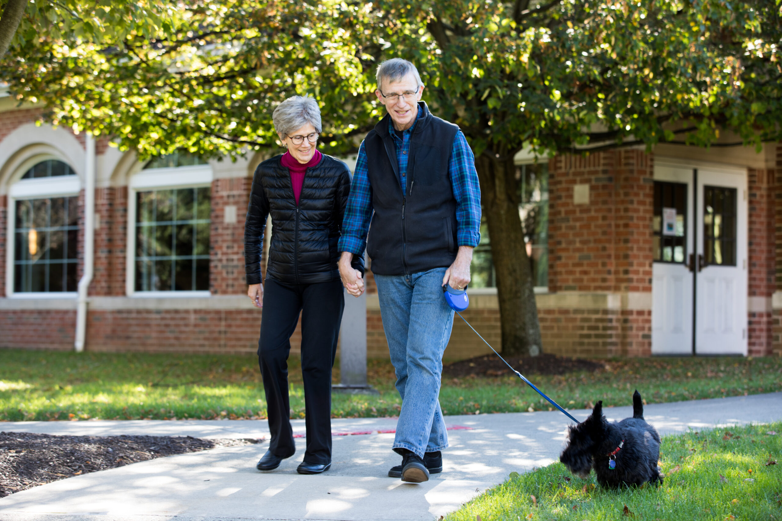 senior couple walking their dog at Meadow Ridge