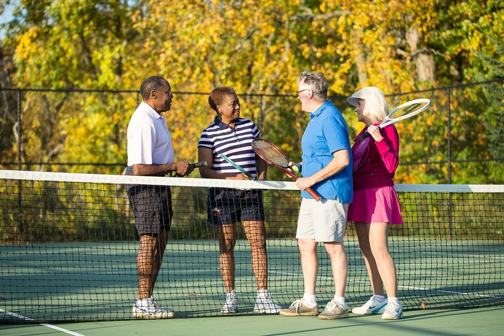 Two senior couples playing tennis