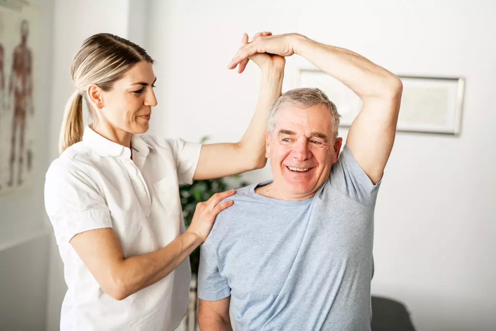 A senior man practicing physical therapy exercises