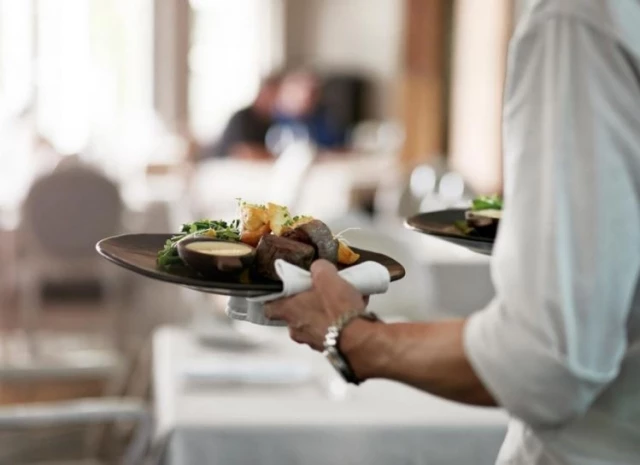 Server bringing dishes to table