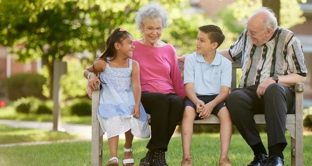 Grandparents sitting with grandchildren outdoors