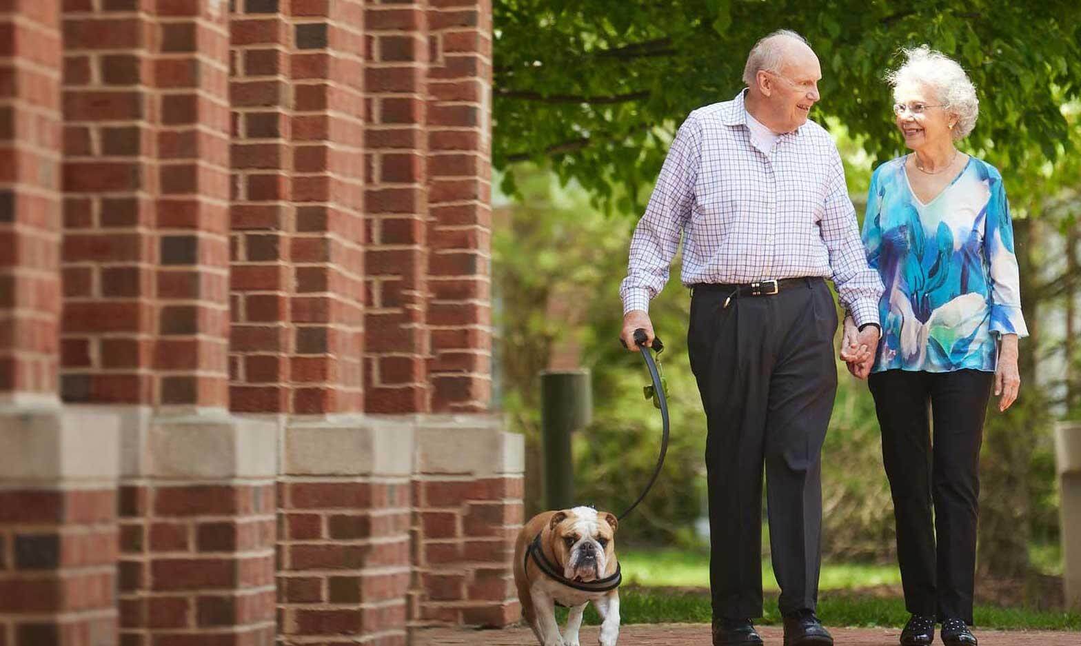 Senior couple walking with dog