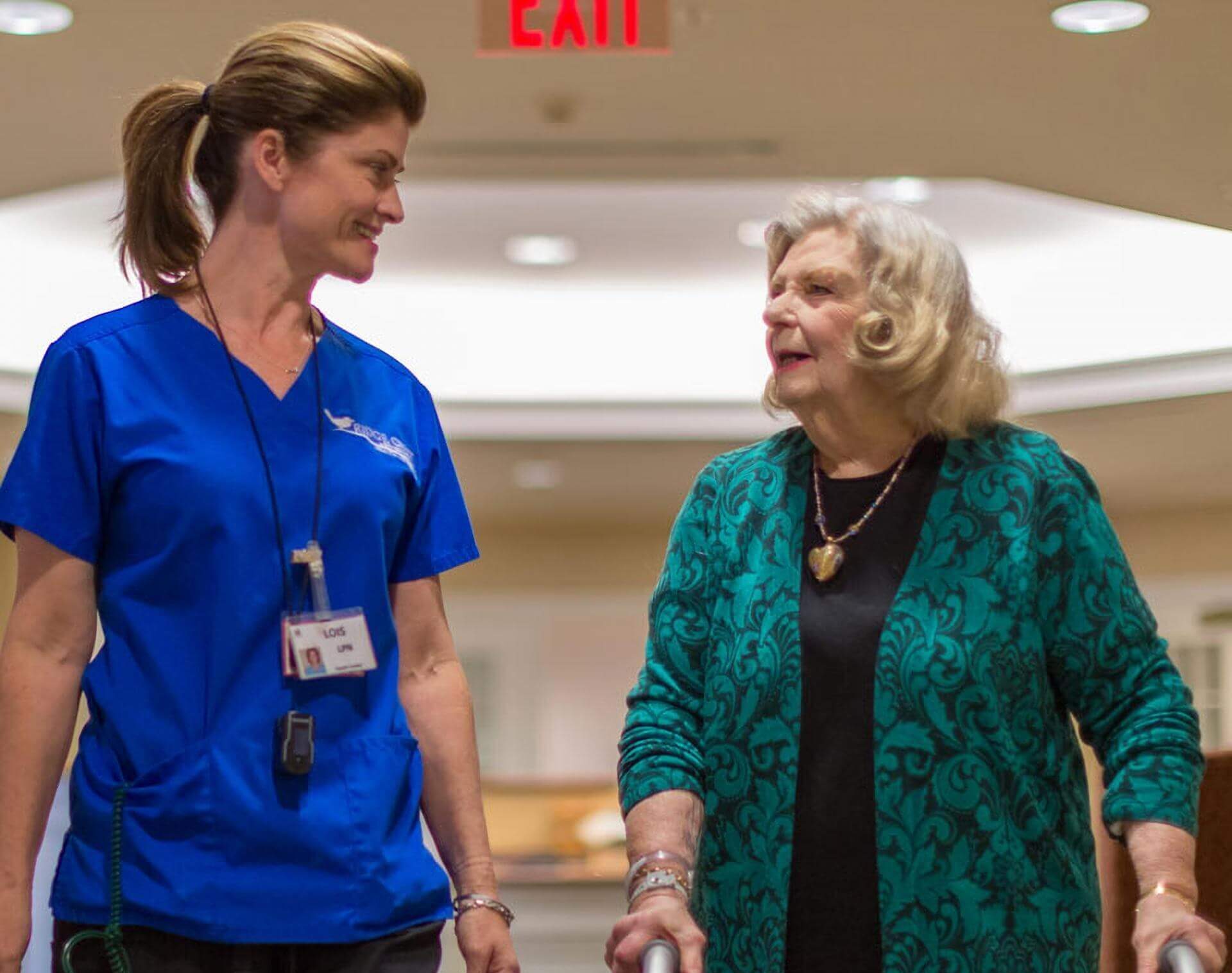A nurse and a resident walking at a skilled nursing facility