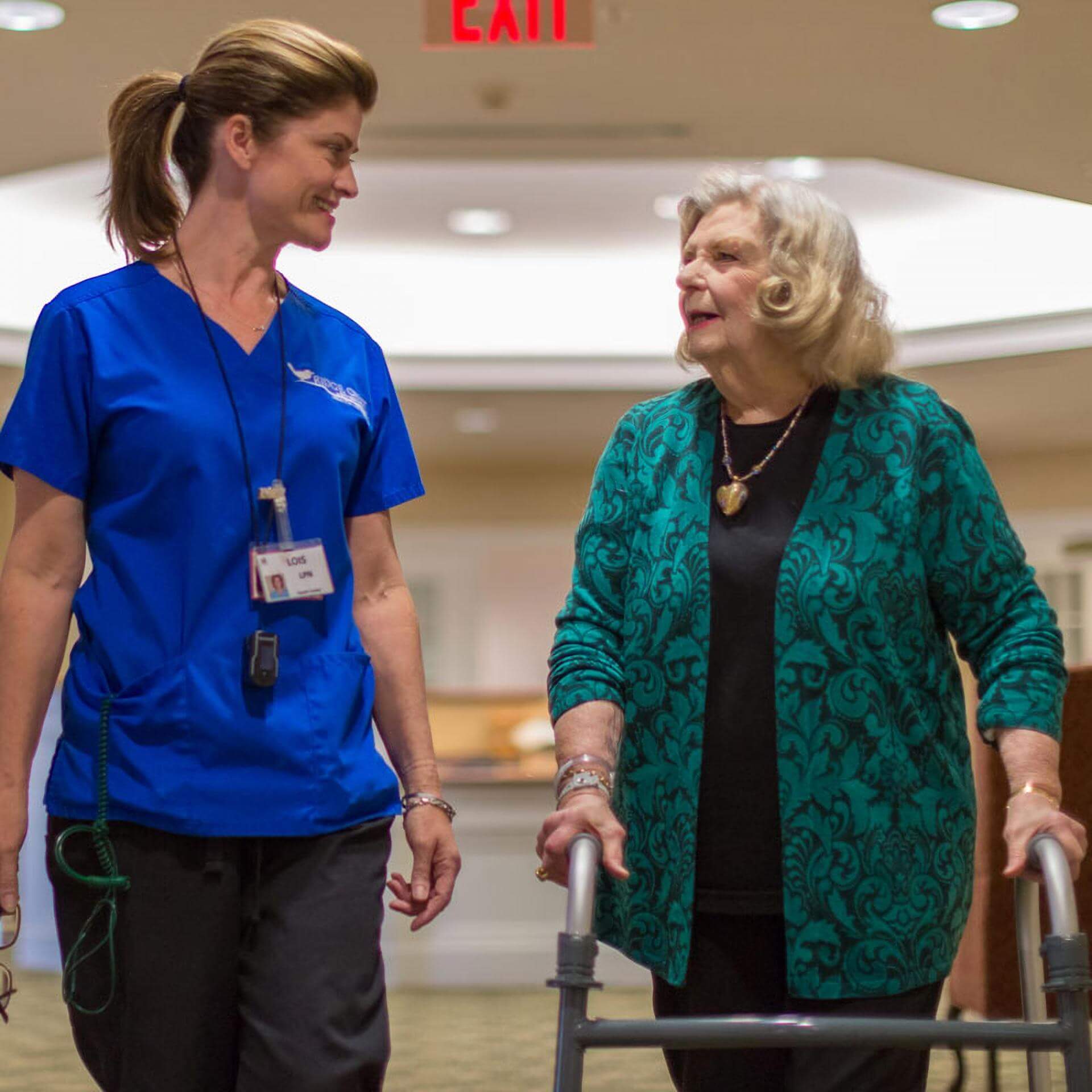A nurse and a resident walking at a skilled nursing facility