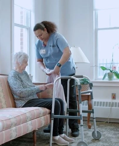 Caregiver helping senior woman with walker