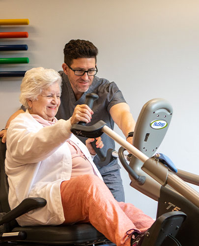 interior resident Judy McGorty exercise machine Mike Santerre helping