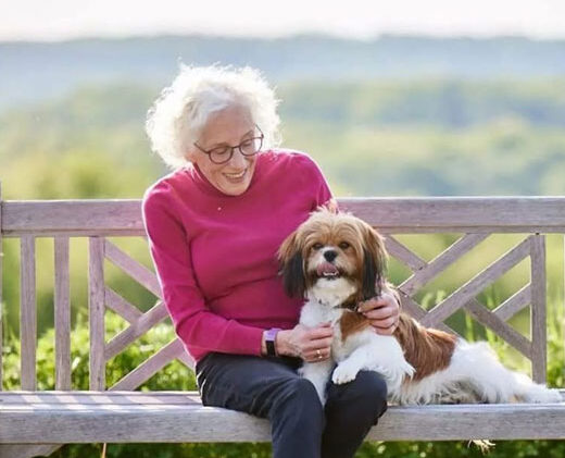 Meadow Ridge resident with her dog sitting on a bench